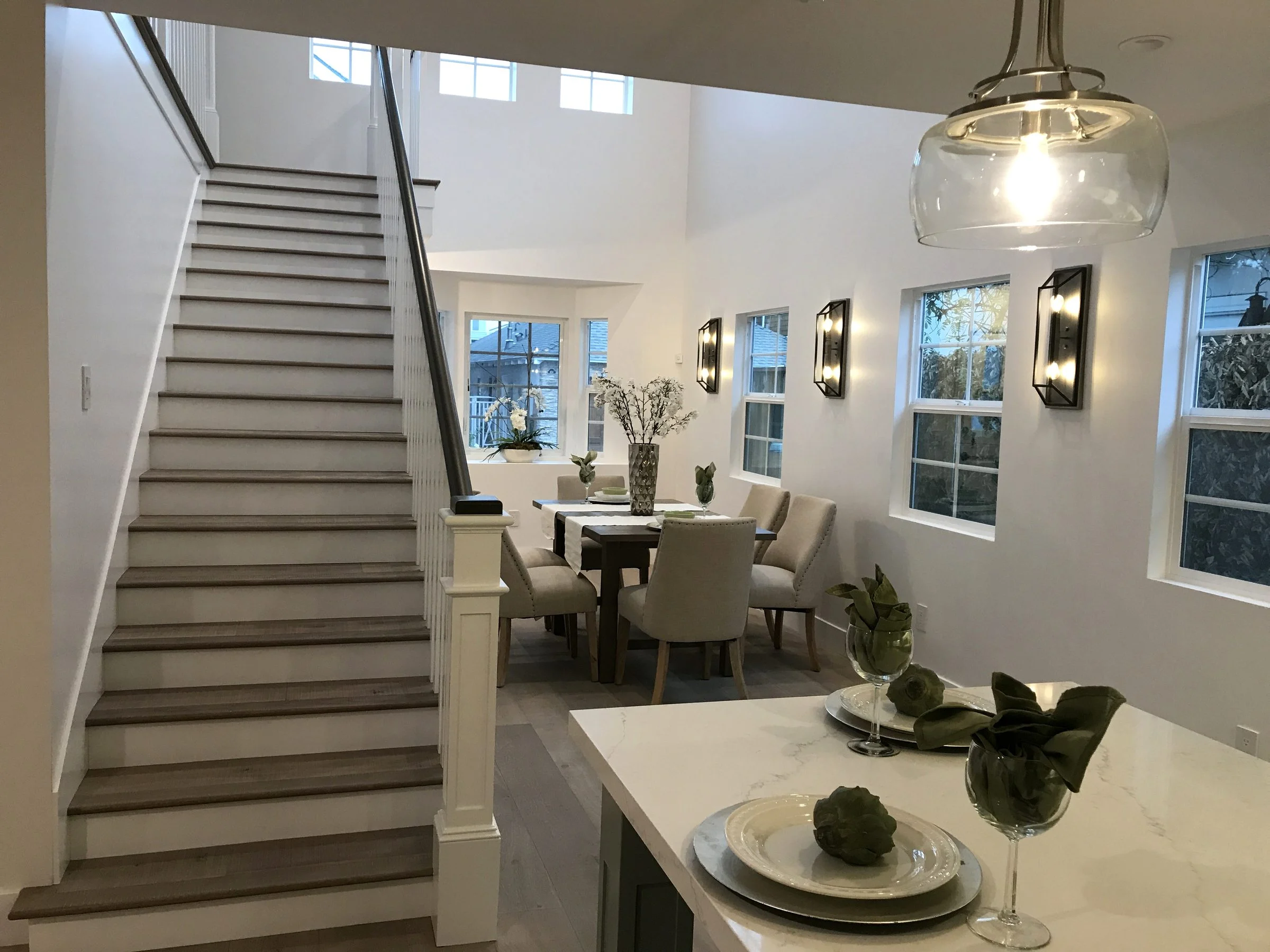 Open staircase beside a dining room and marble kitchen island