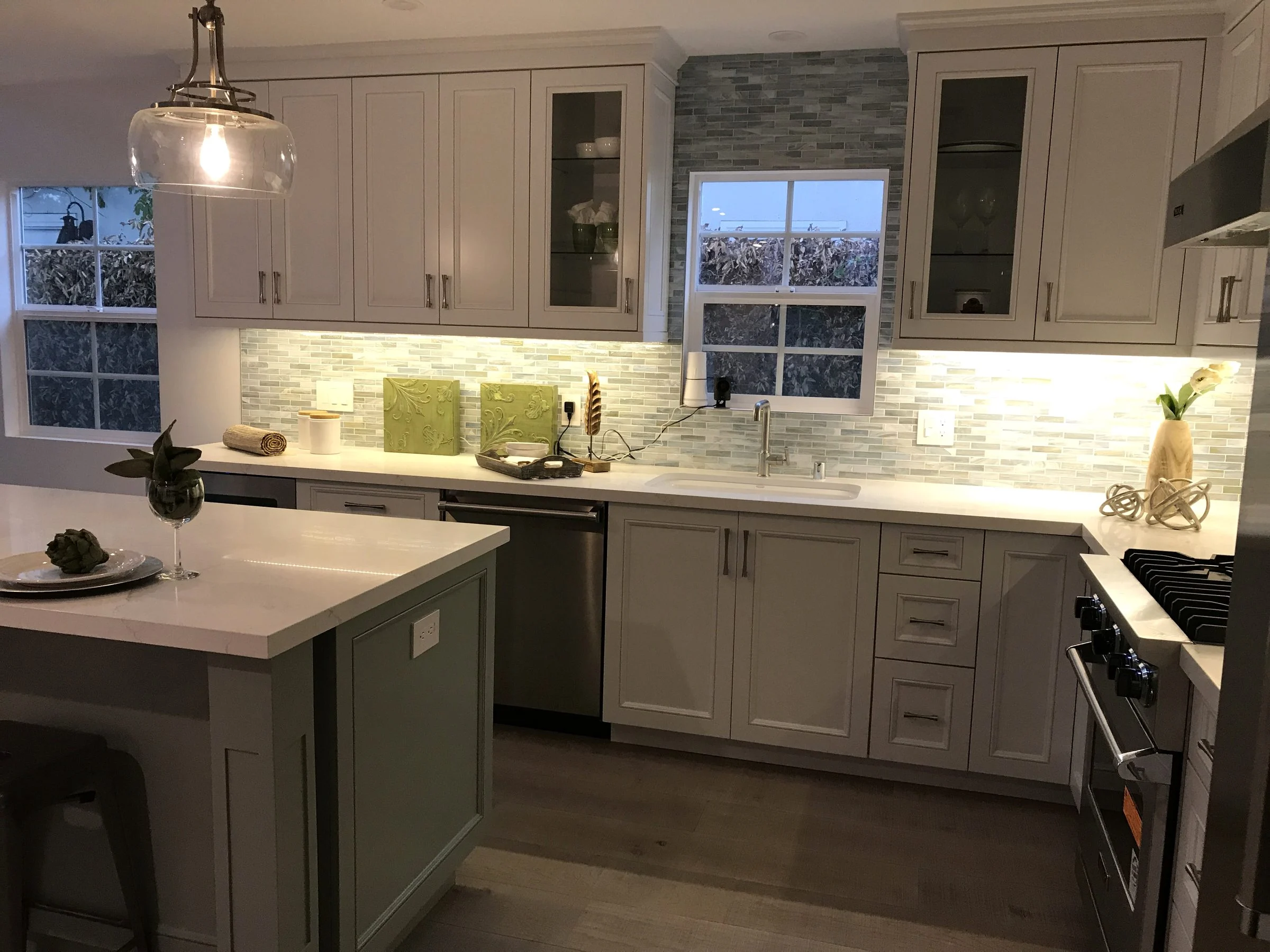 Gray shaker kitchen with an island and glass tile backsplash